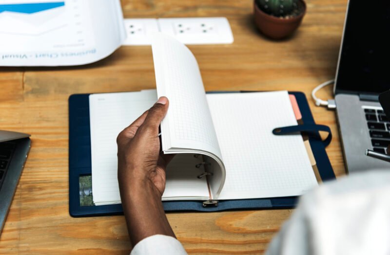 une-femme-d-affaires-verifiant-ses-notes-dans-un-cahier